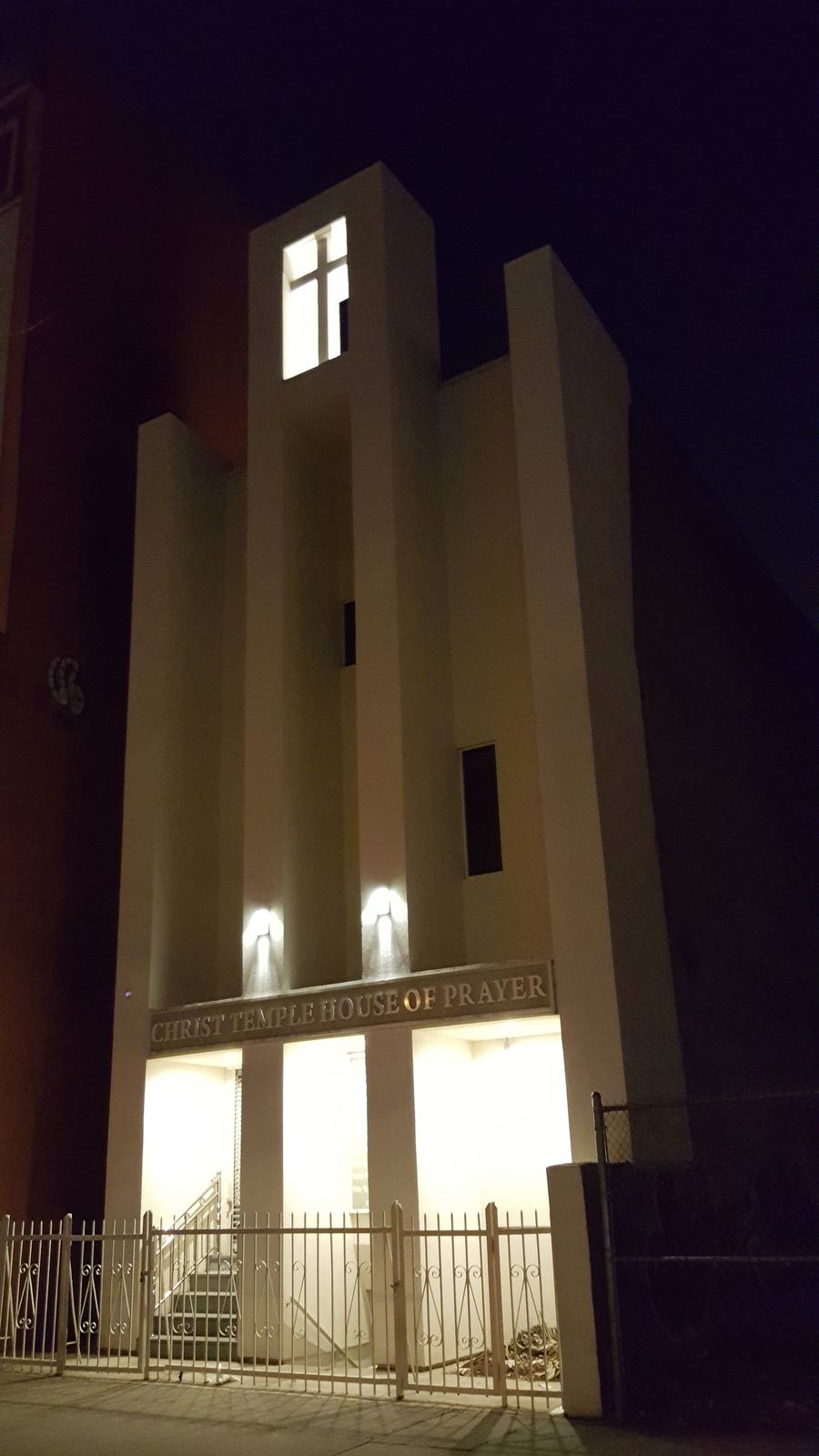 Church tower and cross lit at night